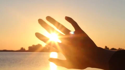 Silhouetted Hand Holding Sun at Sunset Stock Footage 346028597
