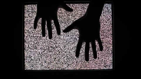 Silhouetted Hands Touching Flickering Static TV Screen Stock Footage 307299413