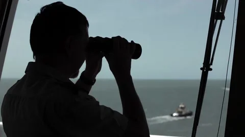 Silhouetted man with binoculars on ship Stock Footage 47240179