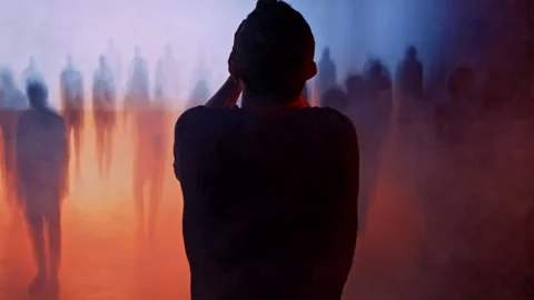 Silhouetted Man Facing Ethereal Crowd In Mysterious Orange Blue Atmosphere Vídeos de archivo 288891537
