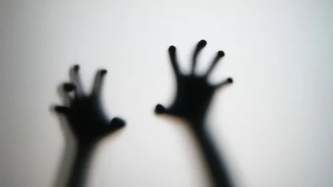 Silhouetted man hands scratch glass, horror movie style shot Stock-Footage 101355363