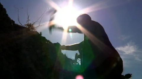 Silhouetted Man Hitting Rocks Outside in the Desert Stock Footage