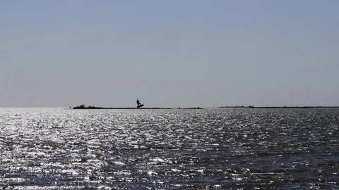 Silhouetted man jumping while kite boarding in near Corpus Christi Texas; Stock Footage 149064389