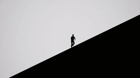 A Silhouetted man running up slanted surface Stock Footage 155224359