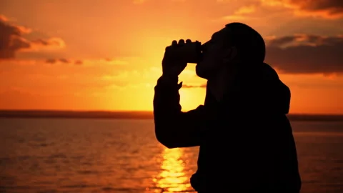 Silhouetted Man at Sunset Drinks Coffee on a Bench Stock Footage 255517848
