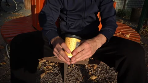 Silhouetted Man at Sunset Drinks Coffee on a Bench Stock Footage 255522359