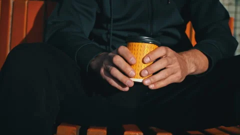 Silhouetted Man at Sunset Drinks Coffee on a Bench Stock Footage 255522512