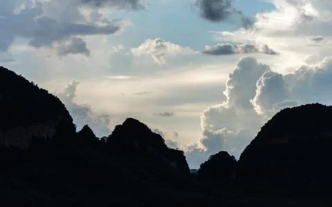 Silhouetted mountains range with cloudy sky Stock Photos