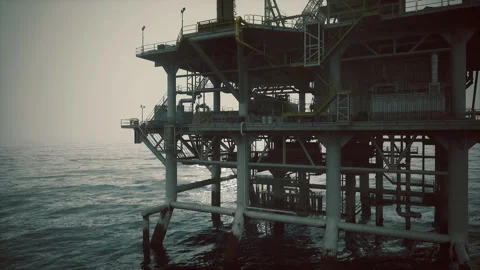 Silhouetted oil extraction platform with shadowed walkways and stormy sky Stock Footage 342921631