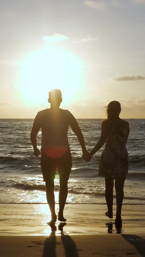 Silhouetted Pair Exploring Sunset Coastal Landscape. Sunset Beach Lovers Video stock 334614718