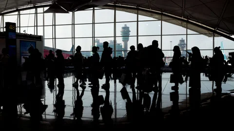 Silhouetted passengers in queue to boarding gate at Hong Kong airport Stock Footage 341004772