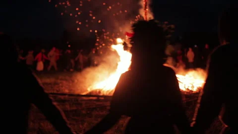 Silhouetted people dancing in front of large fire. Russian ethnic holiday Ivan Video stock 252670853