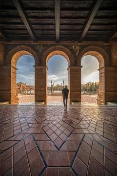 Silhouetted Person Walking Through Arched Corridor, Plaza de espana Square, .. Stock Photos