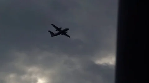 Silhouetted plane takes off overhead, in front of a dramatic cloudscape Stock Footage 80439996