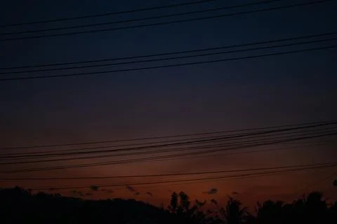 Silhouetted Power Lines Against Sunset Sky Stock Photos