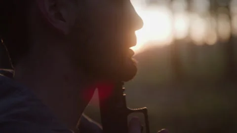 Silhouetted Profile of Disturbed Man Committing Suicide in Dark Blurred Woods Stock Footage 208798821