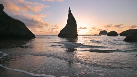 Silhouetted sea stack at sunset. Oregon Coast travel background. Stock Footage 200191440