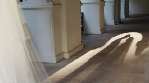 Silhouetted shape of newly wedded husband and wife standing in arch in sun light Vidéo 62516677