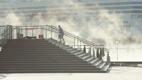 Silhouetted single person walking up steps from steaming outdoor pool Stock Footage 146265320