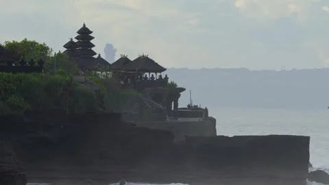 Silhouetted Temple On Edge Of Cliff With Waves Crashing Below At Sunset Vídeos de archivo 347248703