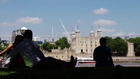 Silhouetted tourists in the shade while sunshine illuminates the Tower of London 스톡 동영상 75995021