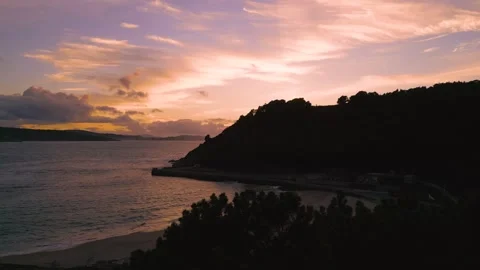 Silhouetted Trees And Mountain By The Beach During Sunset Stock Footage 252831002