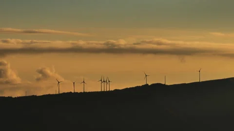 Silhouetted wind turbines standing along a mountain ridge on Sao Miguel Island 库存影片 336192564