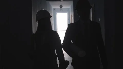 Silhouettes of Architects Going Together along Hallway Stockbeeldmateriaal 100793025