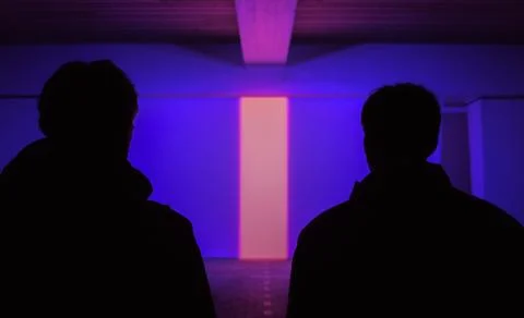 Silhouettes of audience sitting in empty lit theater Stock Photos