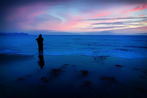 Silhouettes on the beach at dusk Stock Photos