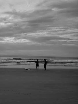 Silhouettes on the Beach at Dusk Stock Photos