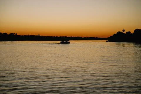 Silhouettes of boat at sunset on the Zambezi River in Zimbabwe Stock Photos