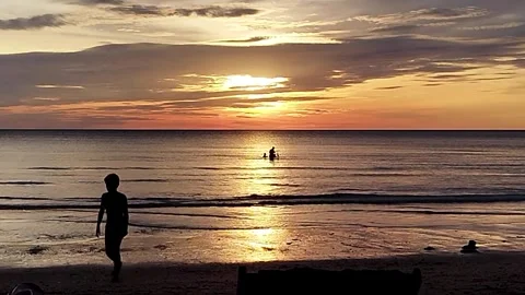 Silhouettes of A boy walking on the Beach at Sunset of Koh Chang, THAILAND Stock Footage 340383568