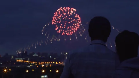 Silhouettes of bride and groom watching fireworks in night sky Vidéo gratuite 77400929