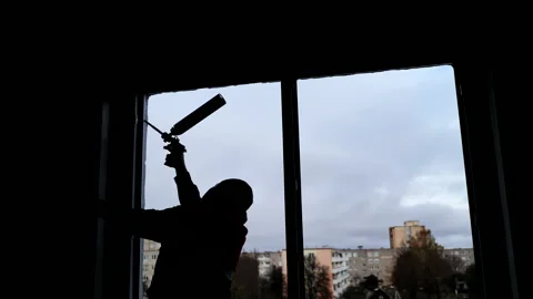 Silhouettes of a builder foaming a wall for installing windows. Stock Footage 142170054
