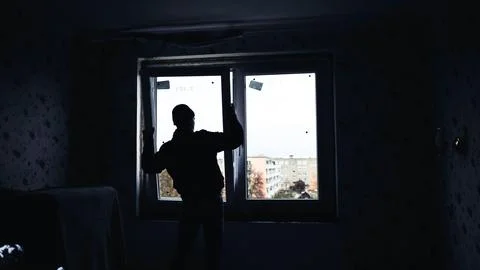 Silhouettes of builders install plastic windows in the house. Stock Photos