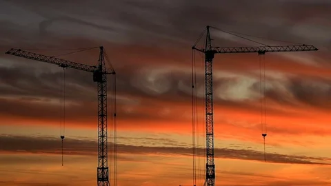 Silhouettes of building cranes against the background of clouds and sunset. Stock Footage 75863449