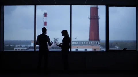 Silhouettes of busy workers standing against the window Video stock 70096490