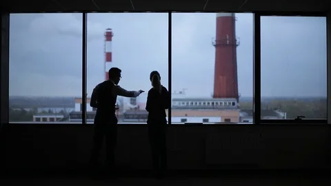 Silhouettes of busy workers standing against the window 動画素材 70097420