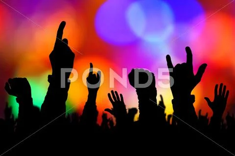 Silhouettes of concert crowd hands supporting band on stage Stock Photos
