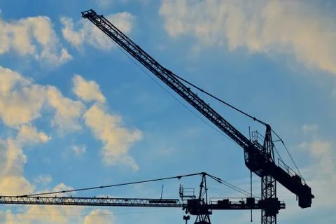 Silhouettes construction cranes Stock Photos