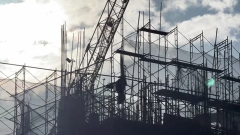 Silhouettes of Construction Scaffolding and crane working Against Cloudy Sky at Stock Footage 340117871