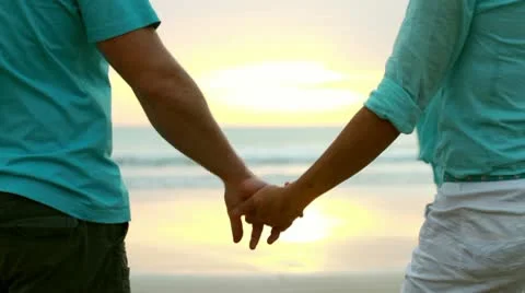 Silhouettes of a couple holding sun in their hands at sunset Stock Footage