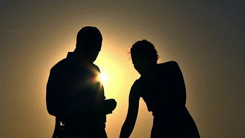 Silhouettes of a couple at sunset Stock Footage 97998366