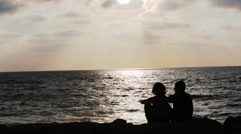 Silhouettes of couples in the evening on the sea Stock Footage 52375474