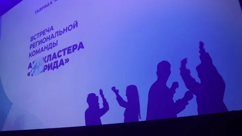 Silhouettes of dancing people on the background of the projector Stock Footage 177140444