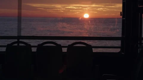 Silhouettes of empty seats inside ferry boat. Sunset Seascape Stock Footage 266827157