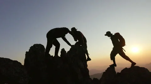 Silhouettes a group of  climbing on mountain and helping. Help and assistan.. Stock Footage 336975442
