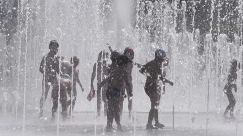 Silhouettes, Kids Having Fun Between Water Splash in Fountain on Street. Heat Video stock 157039174