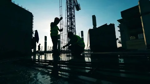 Silhouettes of Labor: Workers on a Construction Site at Dusk Stock Footage 270495235